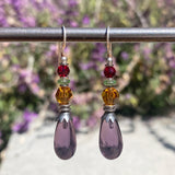 Purple glass earrings. Crystal accents in topaz and red. Silver ear wires. Handwork done in the USA using European glass.