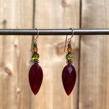 Garnet glass drop earrings. Topaz and green Austrian crystal accents. Metal trim is antiqued bronze with sterling silver ear wires. All handwork done in the USA.