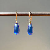 Sapphire blue glass drop earrings with gold trim. Handmade in the USA.