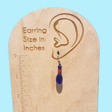 Cobalt glass earrings. Austrian crystal accents in bright orange. Antiqued bronze trim, from our own tooling. Ear wires are sterling silver.