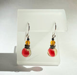 Glass and crystal dangle earrings in orange and clear.