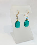 Teal green glass drop earrings with aquamarine Austrian crystal top beads. Gold accents. Handmade in the USA.