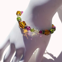 Multicolored beaded bracelet on a mannequin wrist with a white background