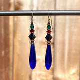 Cobalt chandelier earrings. German glass prisms with Austrian crystal accents in jet, red and emerald. Metal trim is antiqued bronze with sterling silver ear wires. All handwork done in the USA.