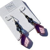 Purple glass earrings on a display card with 'OGC' branding.