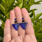 Blue geometric earrings with gold trim.