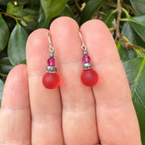 Pink frosted glass earrings with fuchsia crystal top beads. Handmade in the USA. Sterling silver ear wires. 