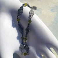 Silver bracelet with green beads on a white mannequin hand
