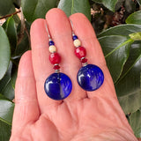 Cobalt glass earrings held in a hand. Czech glass, Austrian crystal. Handmade in the USA.