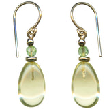 Gold earrings with teardrop-shaped yellow glass drops on a white background