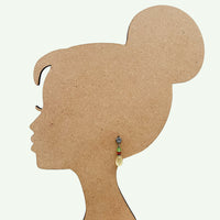 silhouette of a woman's head with an earring displayed on a white background