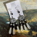 Pair of earrings with decorative design on a scenic background