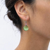 Peridot glass and pink crystal earrings on a model.