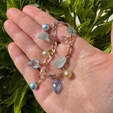 Hand holding a colorful beaded bracelet with a green leafy background