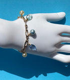 Bracelet with pearls and blue beads on a mannequin hand against a blue background