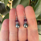Silver crystal earrings with amethyst crystal, held in hand.