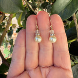 Crystal pearl earrings with Czech glass, held in a hand.