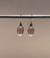 Light mauve glass drop earrings. Metal trim is antiqued bronze with sterling silver ear wires. All handwork done in the USA.