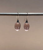Light mauve glass drop earrings. Metal trim is antiqued bronze with sterling silver ear wires. All handwork done in the USA.
