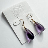 Purple glass earrings with gold trim.

