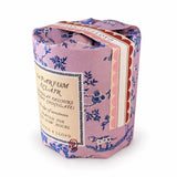 A cup shaped wrapped candle. Wrapped in a pink floral paper sleeve with blue botanical illustrations and a cream paper label. The brand name 'La Parfum & Clair' is visible on the label.