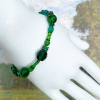 Green beaded bracelet on a white surface with a natural background