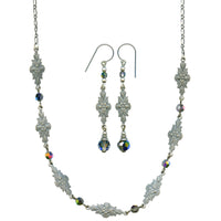 Silver necklace and earrings set with floral designs and colorful beads on a white background