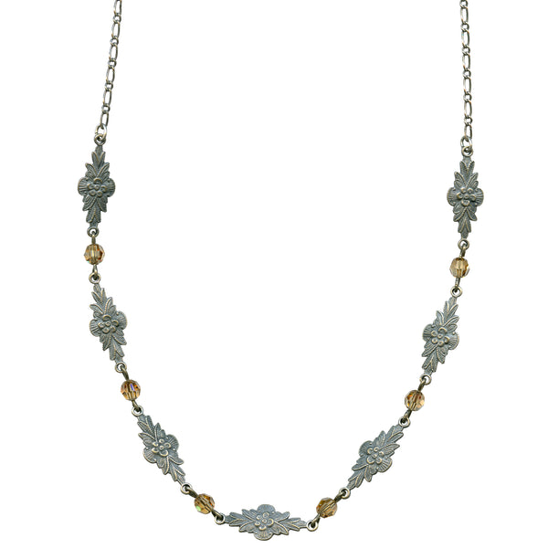 Decorative necklace with floral designs and gold accents on a white background