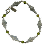 Silver bracelet with floral designs and green crystal beads on a white background