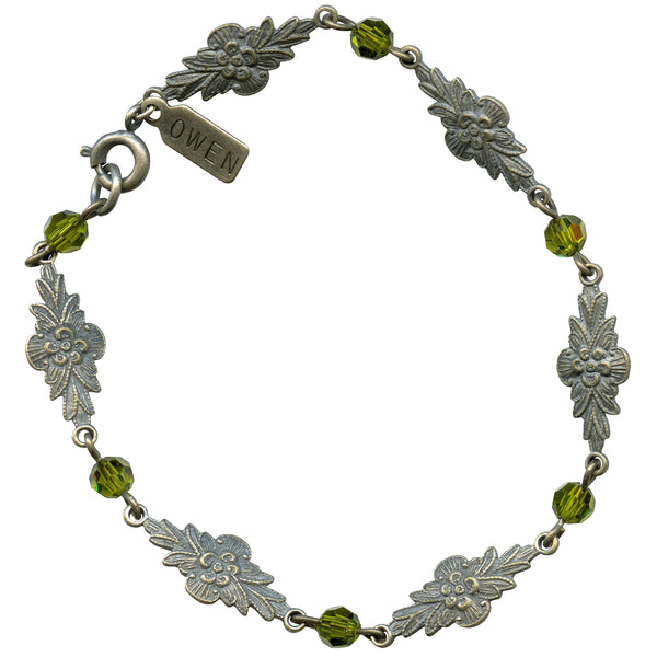 Silver bracelet with floral designs and green crystal beads on a white background