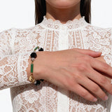 Model wearing handmade bracelet. Jet, clear and green glass. Art Deco era glass. Handmade in the USA.