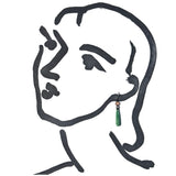 A minimalist black line drawing of a woman's profile wearing a single dangling earring with a green prism and a small metallic top, on a plain white background.