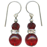 Pair of red beaded earrings with silver accents on a white background
