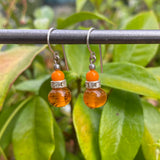 Orange glass earrings with rhinestones and silver trim.