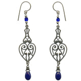 A pair of silver filigree dangle earrings with small blue beads and teardrop-shaped blue gemstones, shown against a plain white background.