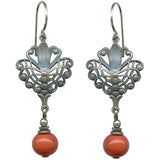 Pair of silver earrings with coral beads on a white background