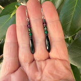 Black prism earrings held in a hand. Antique Czech glass earrings.