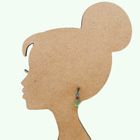 Silhouette of a woman's head with an earring on a white background