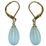 Pair of gold earrings with light blue teardrop-shaped stones on a white background
