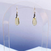 Light yellow glass drop earrings. Antiqued silver-plated brass trim with sterling silver ear wires. All handwork done in the USA.