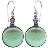 A pair of drop earrings featuring large, oval beads in a pale greenish-blue hue, accented with faceted purple beads and bronze spacer beads, suspended from silver French hook wires.