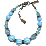 A turquoise and aqua blue beaded bracelet with bronze metal trim and antique glass accents.